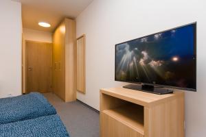 a room with a flat screen tv on a wooden stand at Vila Vivenot in Malá Morávka