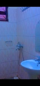 a bathroom with a white sink and a sink at George Suites in Mukono