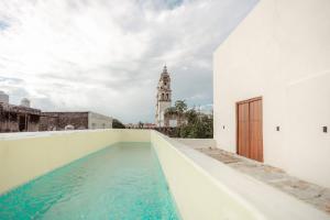 a swimming pool on the roof of a building with a clock tower at Hotel Boutique Casa Jade in Campeche