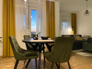 a living room with a dining room table and chairs at Green Lux Apartment in Inđija