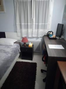 a bedroom with a bed and a desk with a lamp at Chambre bleue lit individuel in Combs-la-Ville