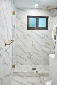 een badkamer met een douche met wit marmer bij House in Dania beach in Dania Beach