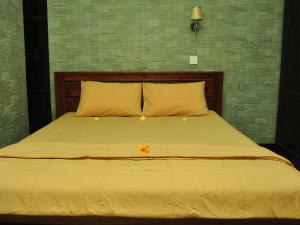 una cama con sábanas amarillas y una flor naranja en ella en Warini Bungalows, en Ubud 23 fotos más