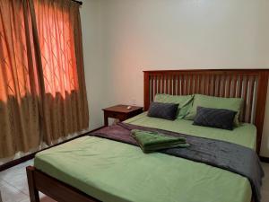 a bedroom with two beds and a window at Arcton Apartment in Paramaribo