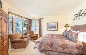 a bedroom with a large bed and a chair at Luxury Lodge with Breathtaking Views in Telluride