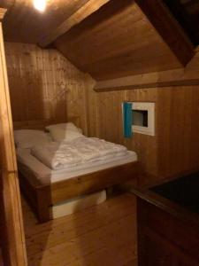 a small bed in a wooden room with at PETITE MAISON AU CALME AVEC VUE MAGNIFIQUE ! in Le Chambon-sur-Lignon
