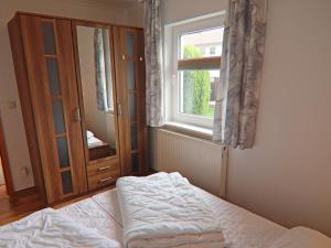 Ferienhäuser am Teich, Zinnowitz في زينوويتز: غرفة نوم بها سرير ونافذة