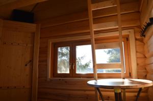 a room with a window in a log cabin at Ansomäe Puhkeala Järvemaja in Otepää