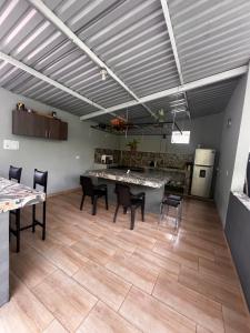 a room with a table and chairs and a kitchen at Hostel no glam boutique in Nocaima