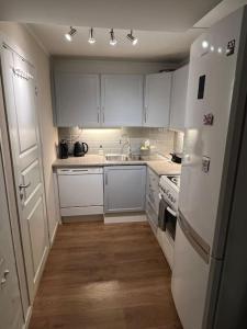 una cucina con mobili bianchi e un frigorifero bianco di Leilighet i sentrum av Tromsø a Guleng
