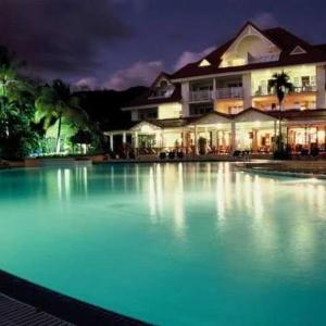 una grande piscina di acqua blu di fronte a una casa di Bambou Suite vue mer à 50 m de la plage et de la piscine a Sainte-Luce
