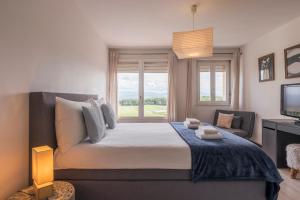a bedroom with a large bed with a window at Amanthos Living Nyon in Duillier
