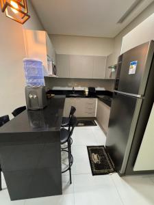 eine Küche mit schwarzer Theke und Kühlschrank in der Unterkunft - Apartamento cânion - Pousada cânion in Canindé de São Francisco + 4 Fotos