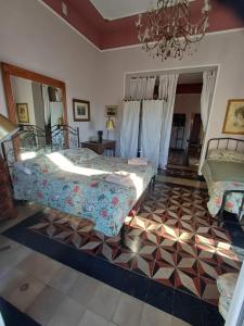 sypialnia z 2 łóżkami i żyrandolem w obiekcie Romantic House spettacolare vista mare unica nel suo genere w mieście Alghero