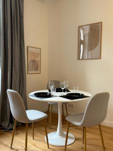 a white table with chairs and wine glasses on it at Apartment Lu16 One Bamberg - modern, zentral mit Terrasse in Bamberg