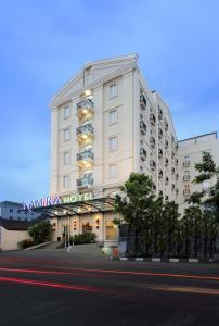 - un grand bâtiment blanc avec un panneau dans l'établissement Hotel Namira Syariah Pekalongan, à Pekalongan