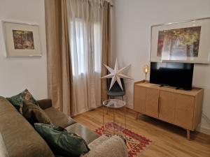 a living room with a couch and a flat screen tv at BELAZUR Entre plage et port in Bandol