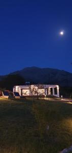 a house in a field at night with the moon at Boutique apartments Myesis in Samothráki