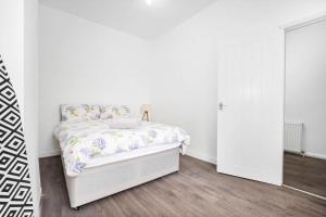 a white bedroom with a bed and a mirror at 1 Bed Apartment Birmingham Resorts World NEC BHX in Birmingham