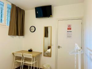 a room with a table and a clock on the wall at Rooms Chima in Madrid