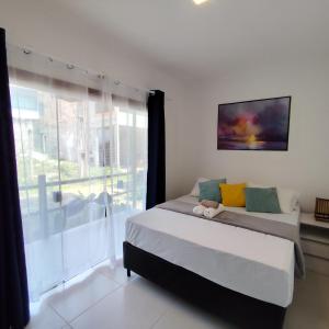 a bedroom with a bed and a large window at Flat novo na Rua Principal, Itacaré BAHIA in Itacaré +72 photos