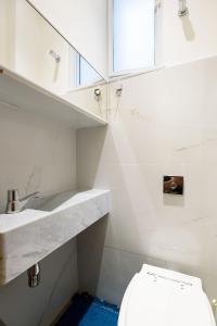 ein weißes Badezimmer mit Toilette und Waschbecken in der Unterkunft Vista lateral mar, rua tranquila e arborizada in Rio de Janeiro