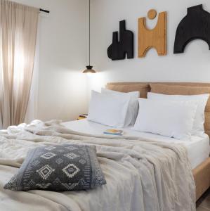 a bedroom with a large bed with white sheets and pillows at Olea White in Skiathos Town