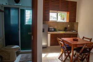 a kitchen with a wooden table with chairs and a sink at Yaxche Condo in Playa del Carmen