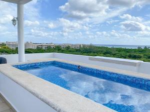 a swimming pool on a balcony with a view of the ocean at Yaxche Condo in Playa del Carmen