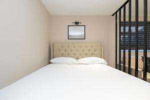 a white bed with two pillows in a bedroom at Modern Studio Apart Large Garden in Stoke on Trent