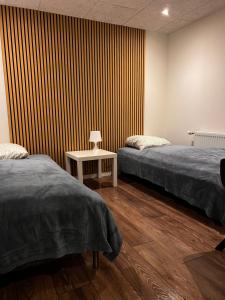 a room with two beds and a striped wall at Hygge Green Retreat Billund in Grønbjerg
