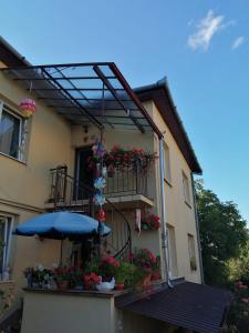 a building with a balcony with flowers and an umbrella at Apartament cu doua camere și grădină in Cluj-Napoca