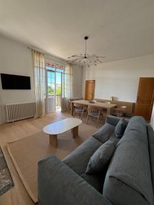 a living room with a couch and a table at Mermoz Vue Mer, Parking in Deauville