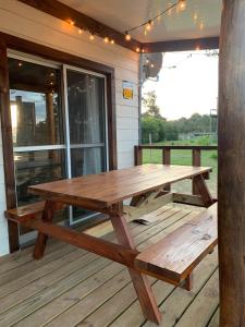 a wooden picnic table on the deck of a house at Laslu in Punta Del Diablo