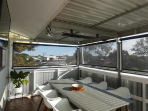 a room with a table and chairs on a balcony at Moonta Bay Stylish large home 3 min walk from beach and jetty in Port Moonta
