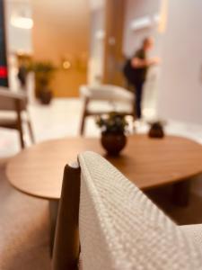 a wooden table and chairs with a person in the background at Hotel Enseada Boa Viagem in Recife +36 photos