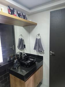 a bathroom with a black sink and a mirror at Studio Libertas in São João del Rei +43 photos