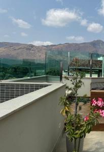 a balcony with flowers and a view of a mountain at Loft excelente no centro de Governador Valadares in Governador Valadares
