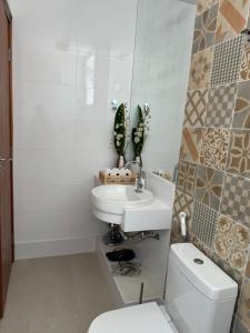 a white bathroom with a toilet and a sink at Loft excelente no centro de Governador Valadares in Governador Valadares +15 photos
