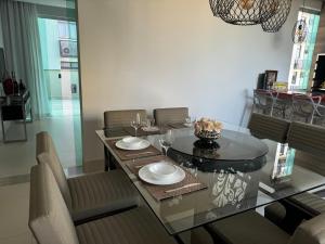 a dining room with a glass table and chairs at Loft excelente no centro de Governador Valadares in Governador Valadares
