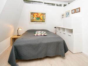 Un dormitorio con una cama en una habitación blanca. en 5 person holiday home in Gilleleje-By Traum, en Gilleleje