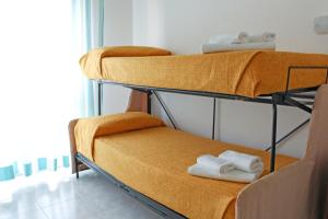 ベッラーリア・イジェア・マリーナにあるHotel Budaの二段ベッド2組が備わる客室です。