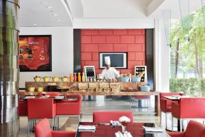 a restaurant with red walls and a chef in the background at Marriott Executive Apartment - Lakeside Chalet, Mumbai in Mumbai
