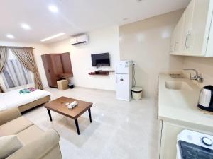 شقق فاخرة Luxury apartments في الرياض: مطبخ وغرفة معيشة مع أريكة وطاولة