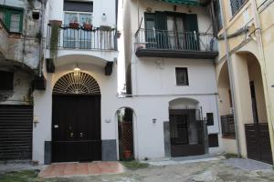 a white building with black doors and a balcony at Corte San Giovanni Battista in Angri