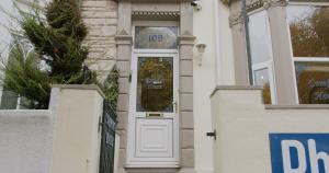 a white door of a house with a sign on it at Free Parking, Entire 8 Ensuite Bedroom Townhouse, Fully Equipped Kitchen, Dining Room & Lounge, Perfect for Family Gatherings, Long Term Contractor, Relocation, etc Stays, 15 mins to Nissan, 20 mins to Sunderland & Newcastle, See our Site for Assurance in South Shields