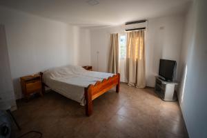 a bedroom with a bed and a flat screen tv at Ciro Dpto in Federación