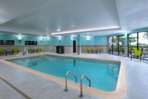 a pool in a hotel with chairs and tables at SpringHill Suites by Marriott Dallas DFW Airport East Las Colinas Irving in Irving