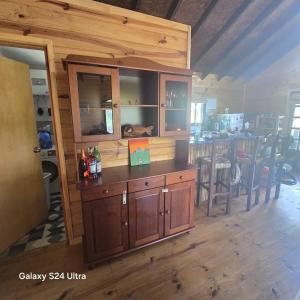 a kitchen with a large wooden cabinet and a table at Cabaña MISUEÑO in Punta Del Diablo