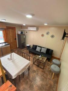 una sala de estar con un sofá y una mesa en Cabañas de centro osorno, en Osorno